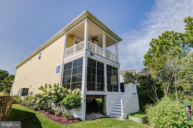 back of house featuring ceiling fan, a sunroom, and a balcony