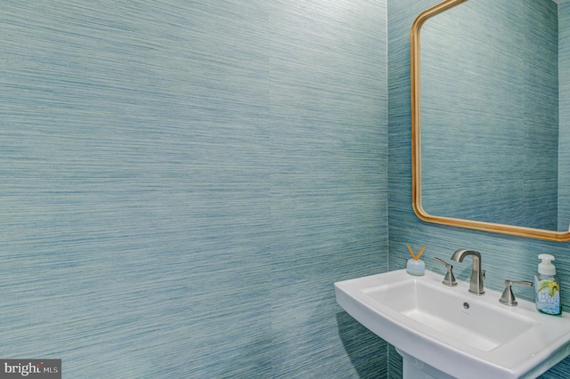 bathroom featuring tile walls and sink