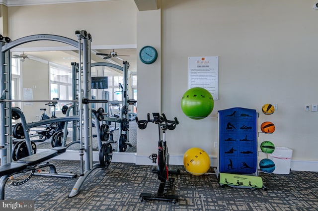 gym featuring ceiling fan and ornamental molding