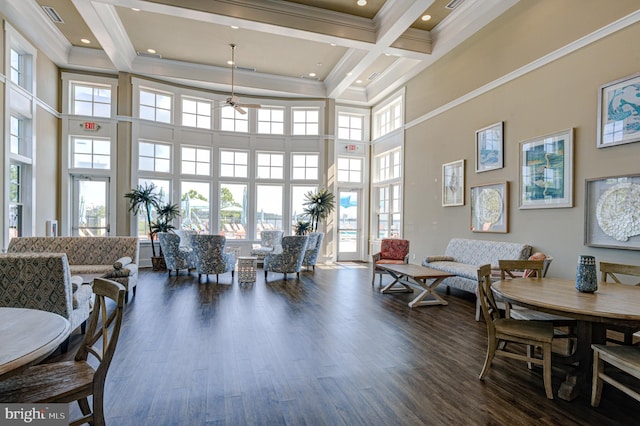 interior space with ornamental molding, beam ceiling, dark hardwood / wood-style flooring, and a high ceiling