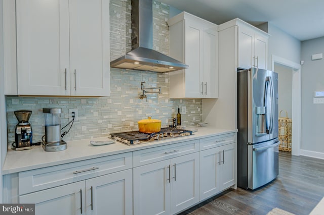 kitchen featuring white cabinetry, stainless steel appliances, dark hardwood / wood-style flooring, and wall chimney range hood