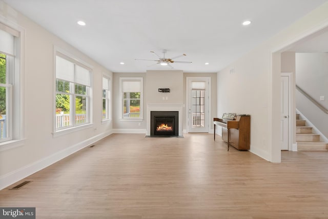 unfurnished living room featuring stairway, light wood-style flooring, and recessed lighting