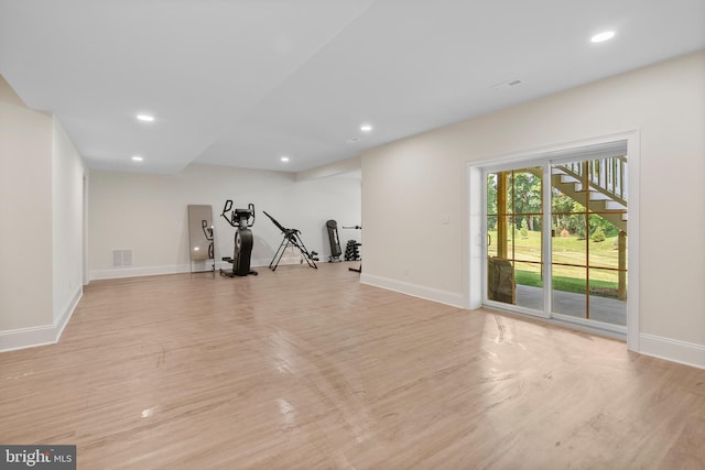 exercise room with light wood-type flooring, visible vents, and baseboards