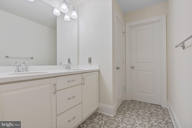 bathroom featuring double vanity, tile patterned flooring, baseboards, and a sink