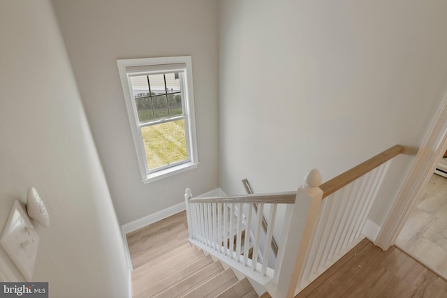 stairs featuring wood finished floors and baseboards