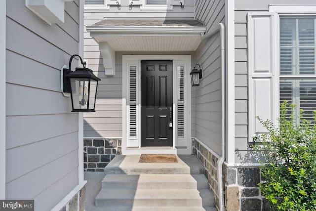 property entrance with stone siding and roof with shingles