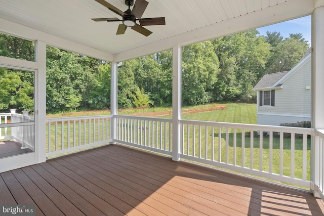 wooden terrace with a ceiling fan and a lawn