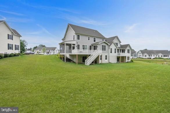 back of property with a residential view, a lawn, stairway, and a wooden deck