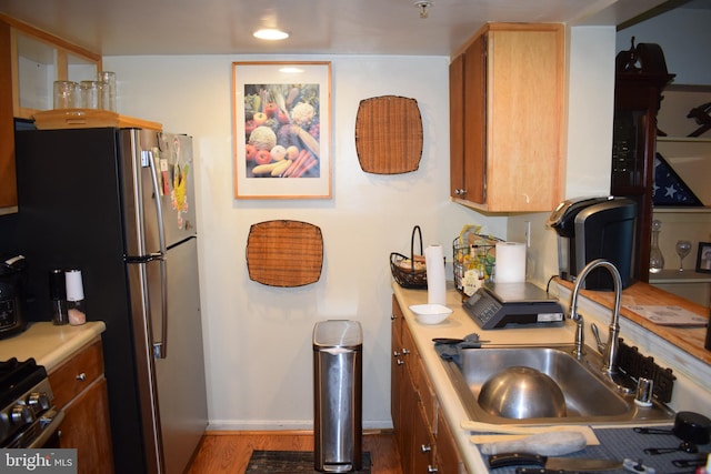 kitchen with black range, dark hardwood / wood-style floors, and sink