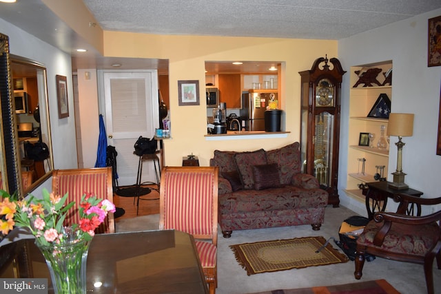 carpeted living room featuring a textured ceiling