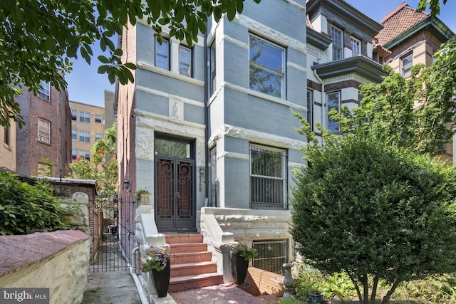 view of front of property featuring a gate and brick siding