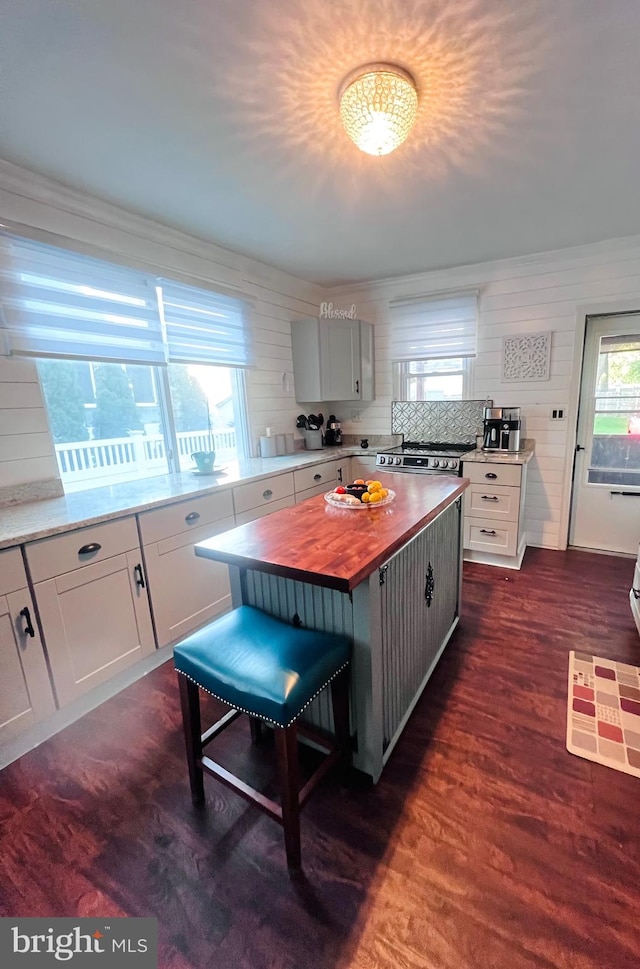 kitchen with backsplash, white cabinetry, a center island, wood counters, and dark hardwood / wood-style floors