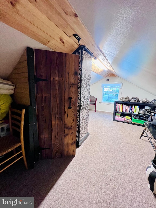 bonus room featuring a textured ceiling, wooden walls, carpet flooring, and vaulted ceiling