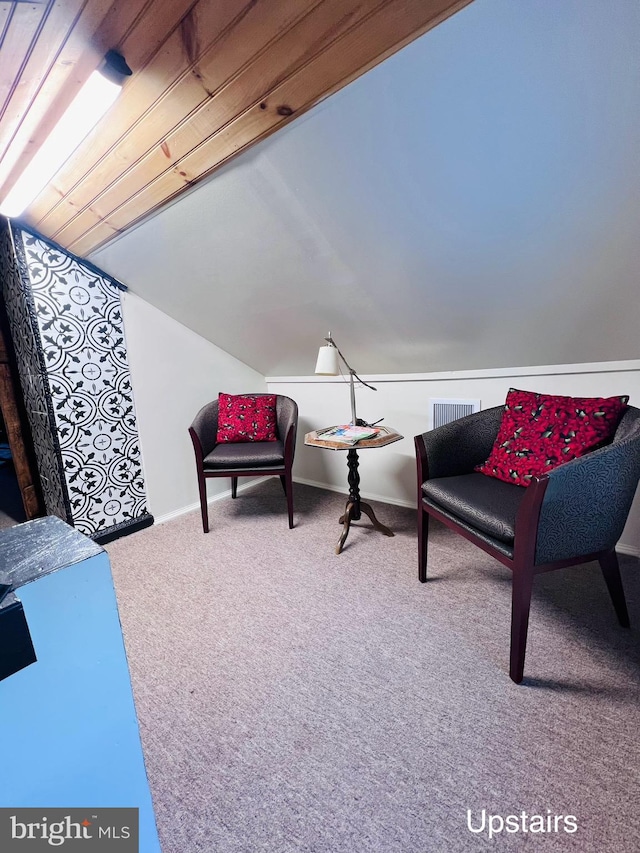 sitting room with carpet flooring and vaulted ceiling