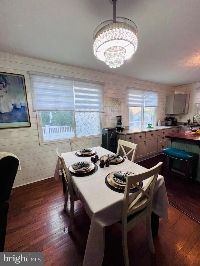 dining area with dark wood-type flooring and a chandelier