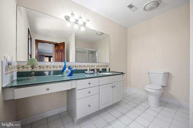 bathroom with dual bowl vanity, tile patterned floors, and toilet