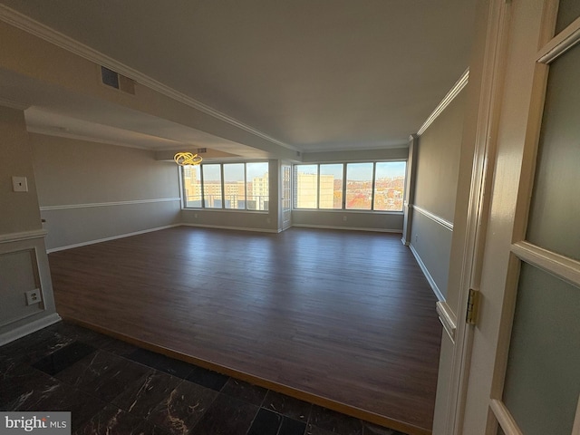 empty room with ornamental molding and dark hardwood / wood-style flooring