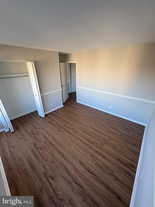 unfurnished bedroom with dark wood-type flooring