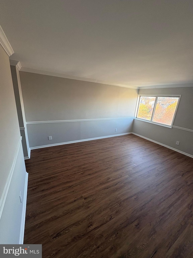 spare room with dark hardwood / wood-style flooring and ornamental molding