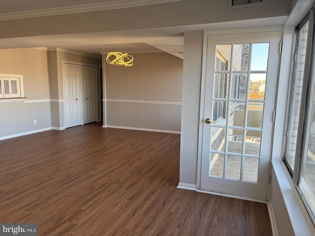 empty room with crown molding and dark hardwood / wood-style flooring