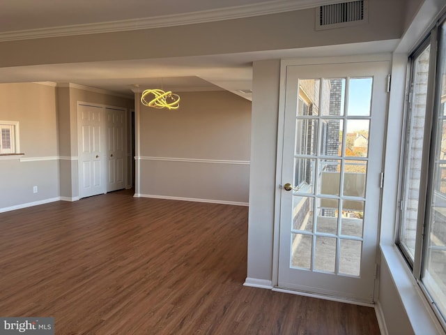 interior space with dark hardwood / wood-style floors, an inviting chandelier, and crown molding