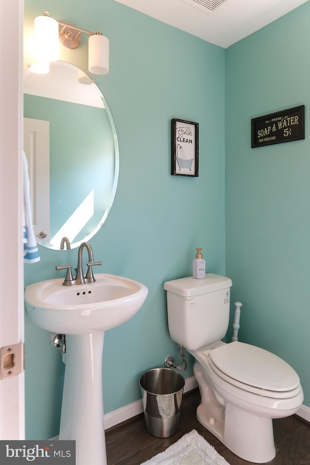 bathroom featuring toilet and wood-type flooring