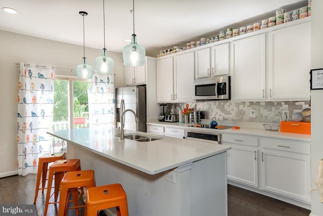 kitchen featuring stainless steel appliances, a center island with sink, and a kitchen breakfast bar