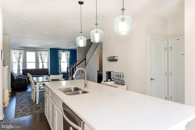 kitchen with a center island with sink, dishwasher, dark wood-type flooring, decorative light fixtures, and sink