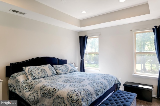 bedroom featuring multiple windows and hardwood / wood-style floors