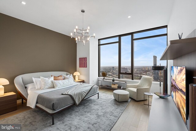 bedroom with an inviting chandelier and light hardwood / wood-style floors