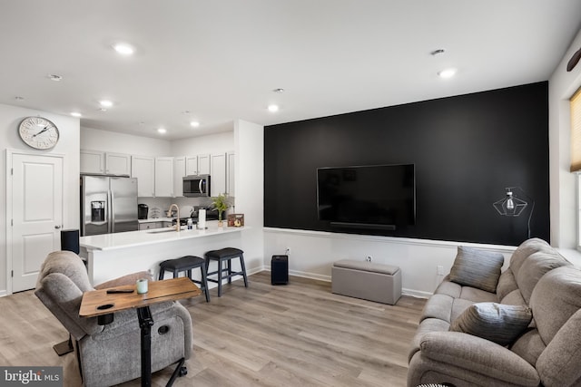 living room with sink and light hardwood / wood-style floors