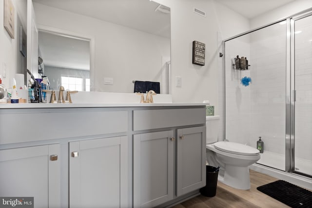 bathroom featuring vanity, toilet, walk in shower, and hardwood / wood-style floors