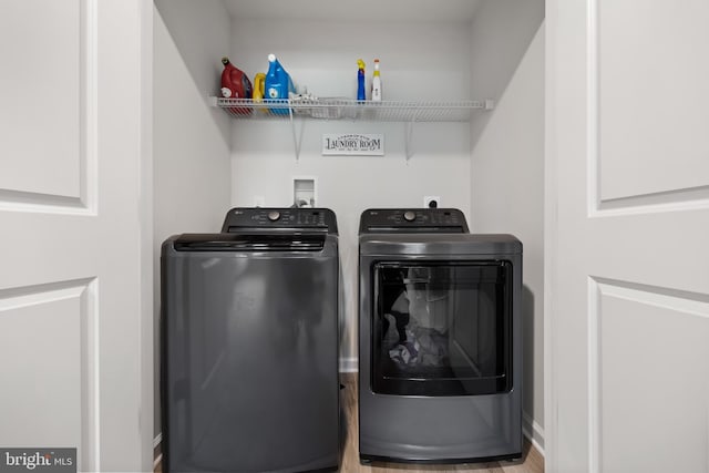 washroom featuring washer and clothes dryer and light hardwood / wood-style floors