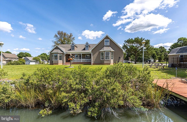 back of house featuring a lawn and a water view