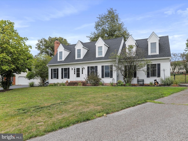 cape cod-style house featuring a garage and a front yard