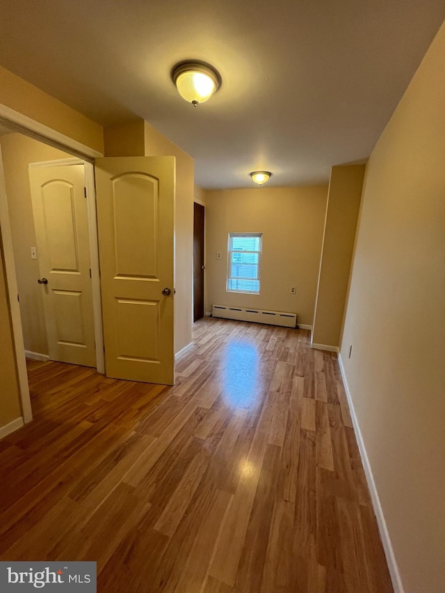 hall featuring wood-type flooring and a baseboard radiator