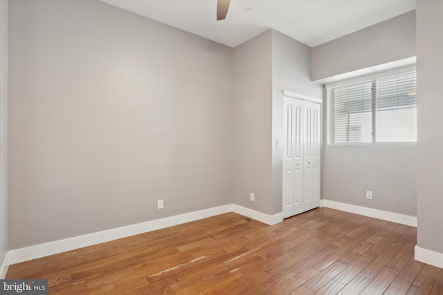 unfurnished bedroom with hardwood / wood-style floors, ceiling fan, and a closet