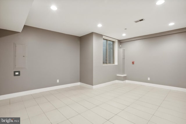 basement featuring electric panel and light tile patterned flooring