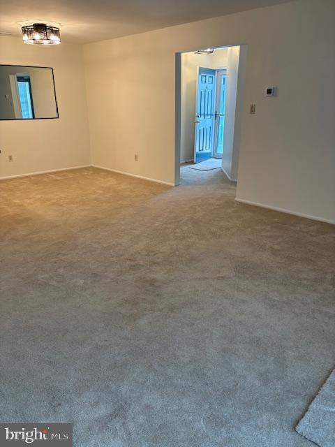 carpeted spare room featuring baseboards