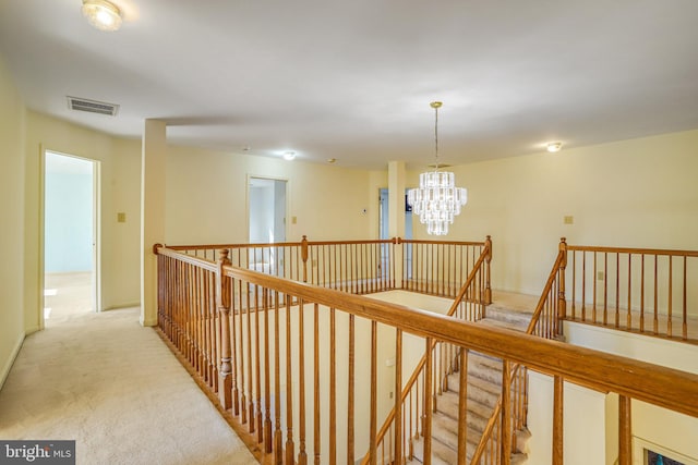 corridor featuring light colored carpet and a chandelier