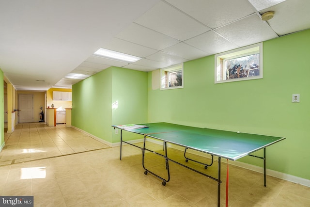 game room with light tile patterned floors and a paneled ceiling