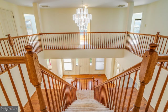 stairway with a chandelier and a high ceiling