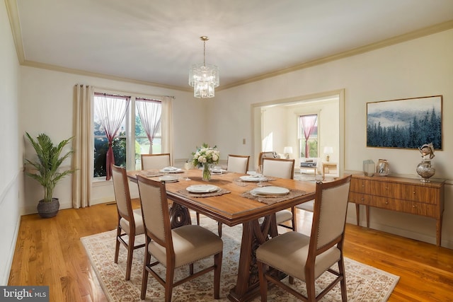 dining area with a chandelier, light hardwood / wood-style flooring, and crown molding