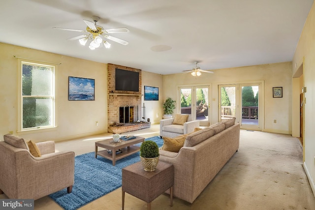 living room with ceiling fan, french doors, light colored carpet, and a brick fireplace