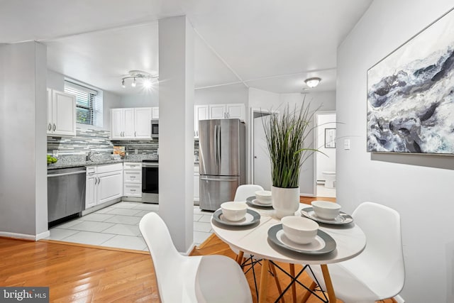 dining area featuring sink and light wood-type flooring