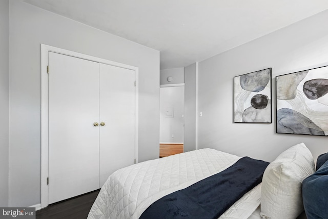 bedroom with dark wood-type flooring and a closet