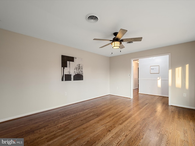 unfurnished room with visible vents, baseboards, wood finished floors, and a ceiling fan