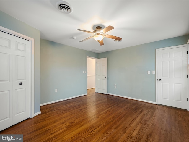 unfurnished bedroom featuring visible vents, wood finished floors, a closet, baseboards, and ceiling fan