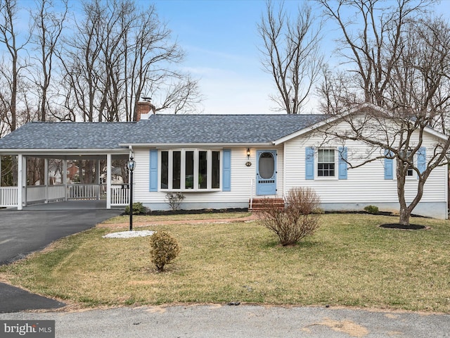 ranch-style home featuring an attached carport, a shingled roof, entry steps, a chimney, and driveway