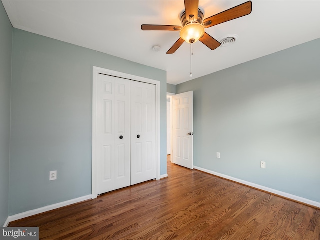 unfurnished bedroom with visible vents, wood finished floors, a closet, baseboards, and ceiling fan